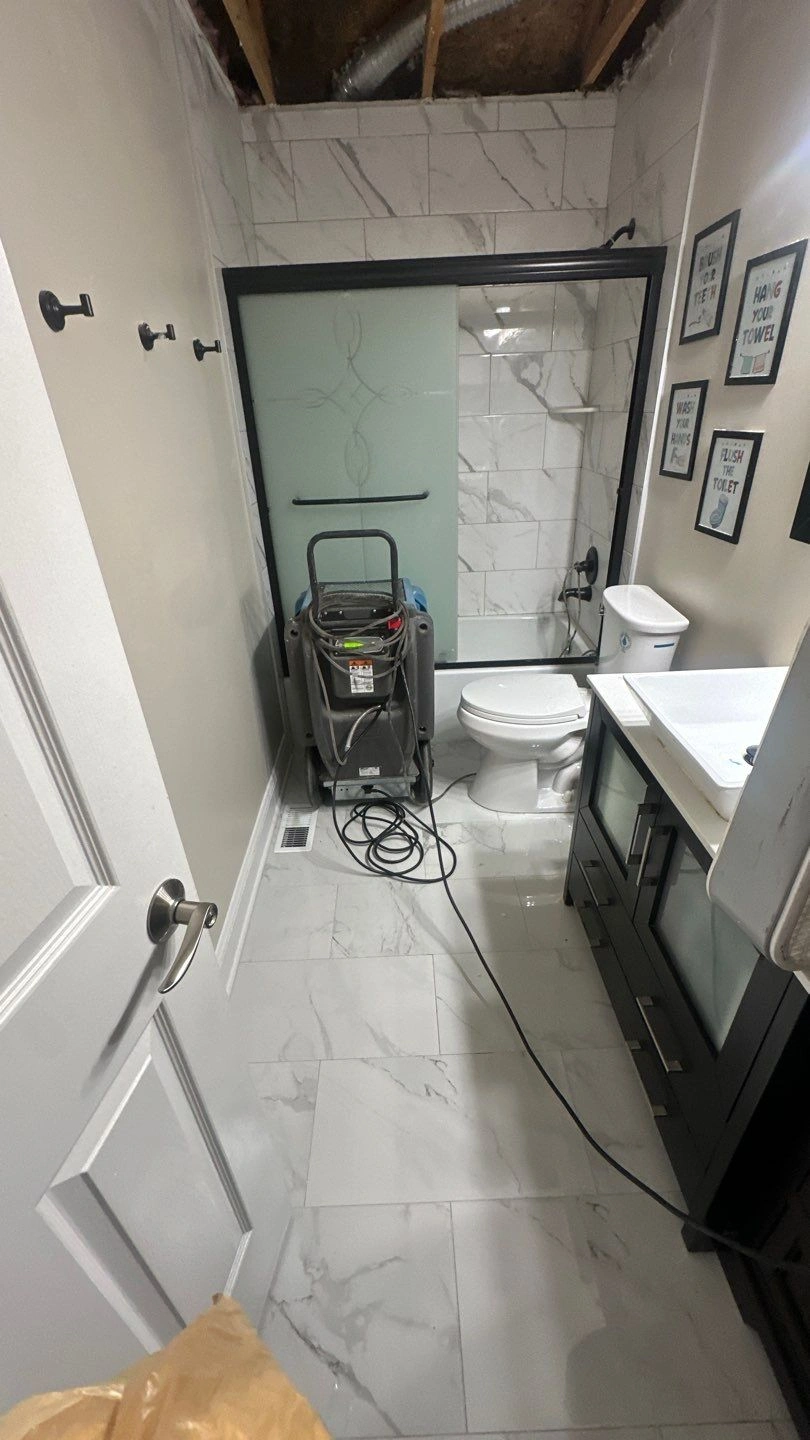 Bathroom renovation in progress with cleaning equipment